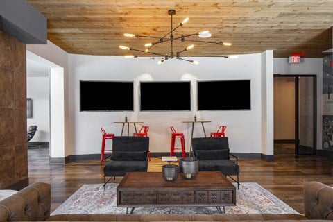 a living room with chairs and a table and a chandelier